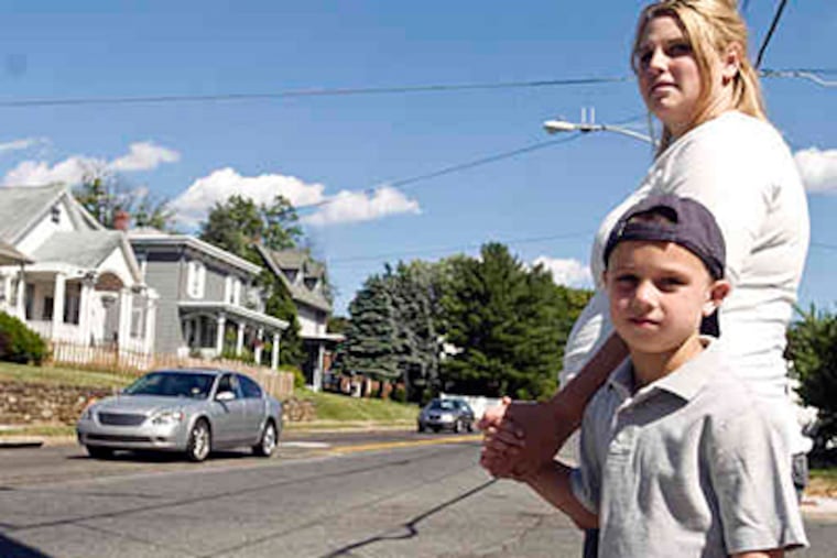 Tarin Davey with Malachi Davey, 6, on Byberry, the same road he took Friday to walk home from a fair at Comly Elementary - and back. "I wanted to find Mommy," he said of the episode. (Ron Tarver / Staff)