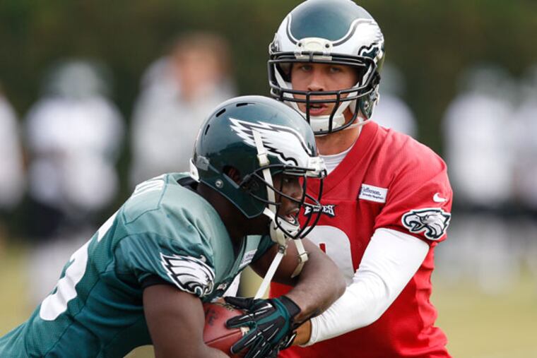 LeSean McCoy (left) takes a hand-off from Nick Foles during Eagles practice at the NovaCare Complex. (David Maialetti/Staff Photographer)