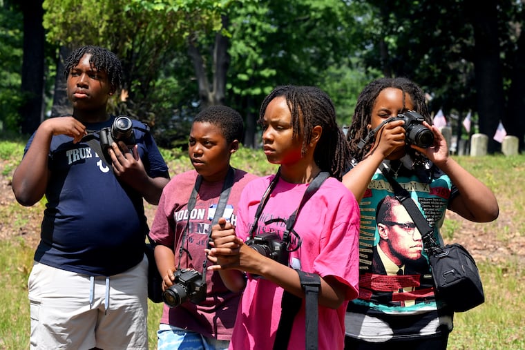 Campers take photographs at Mount Peace Cemetery during the Underground Railroad camp in Lawnside last week. From left are: Nasir Lewis, 12, of Medford; Joel Kurtz, 11, of Haddon Heights: Nailah Ikhlas, 11, of Willingboro: and Tsahai Qadir, 11, of Lawnside. The middle school students worked with Camden photographer Erik James Montgomery taking their own pictures on visits to railroad and historic sites in Lawnside.