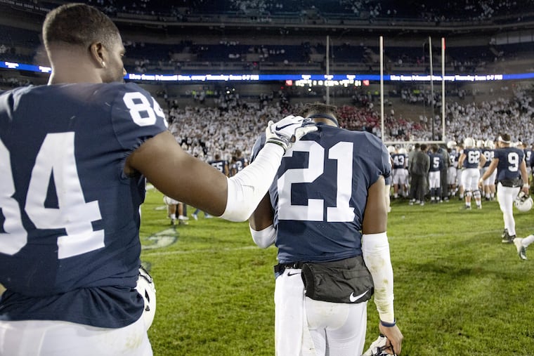 Penn State's Juwan Johnson comforts cornerback Amani Oruwariye on Saturday.