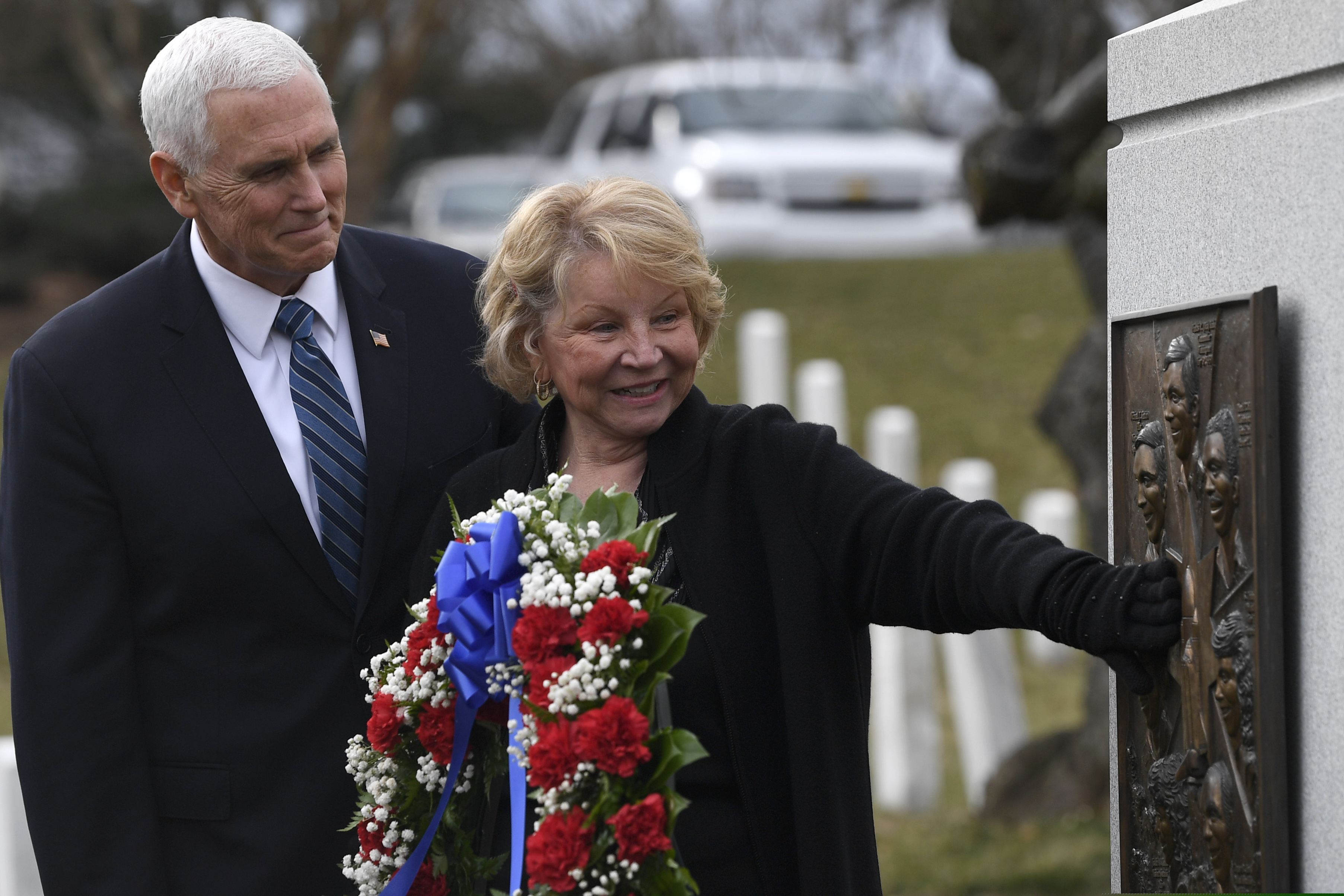 Vice President Mike Pence watches as June Scobee-Rodgers, widow of Challenger commander Dick Scobee, touches the Challenger memorial during the NASA Day of Remembrance ceremony at Arlington National Cemetery in Arlington, Va., Thursday, Feb. 7, 2019.