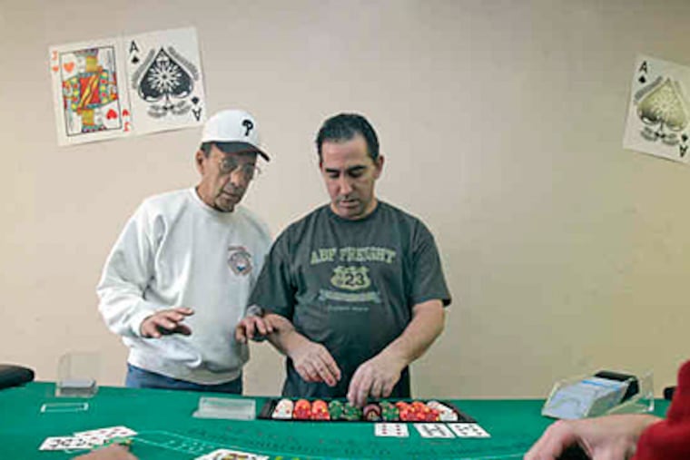 John Palumbo, 75, gives suggestions to student Carlo Altieri, 47. Palumbo hopes to get state approval for his school, or it may close Friday. (Bonnie Weller / Staff)