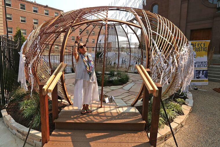 Roses Madrigale of Downingtown visits the grotto, which included more than 30,000 streamers bearing prayers during a dedication ceremony. (DAVID SWANSON/Staff Photographer)