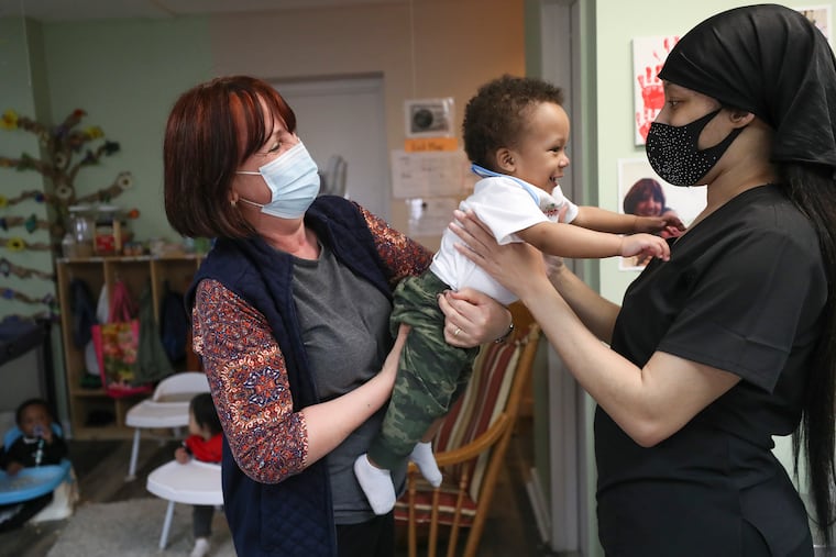 Teneema Tibbs (right) picks up her son, James, from his teacher, Mirjeta Teneqexhiu at the Little Learners Literacy Academy in South Philadelphia.