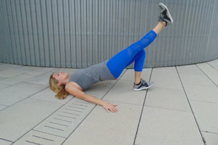 Demonstrating a single leg glute bridge.