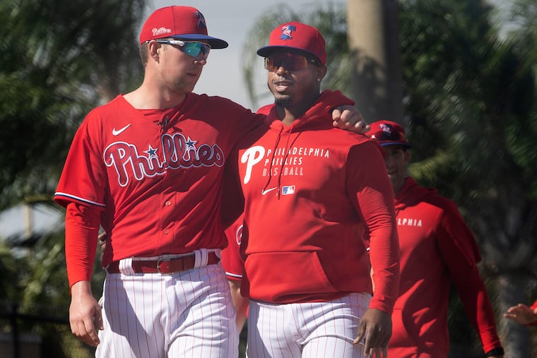 Rhys Hoskins, left, and Jean Segura embrace during spring practice at Spectrum Field in Clearwater, Fla.