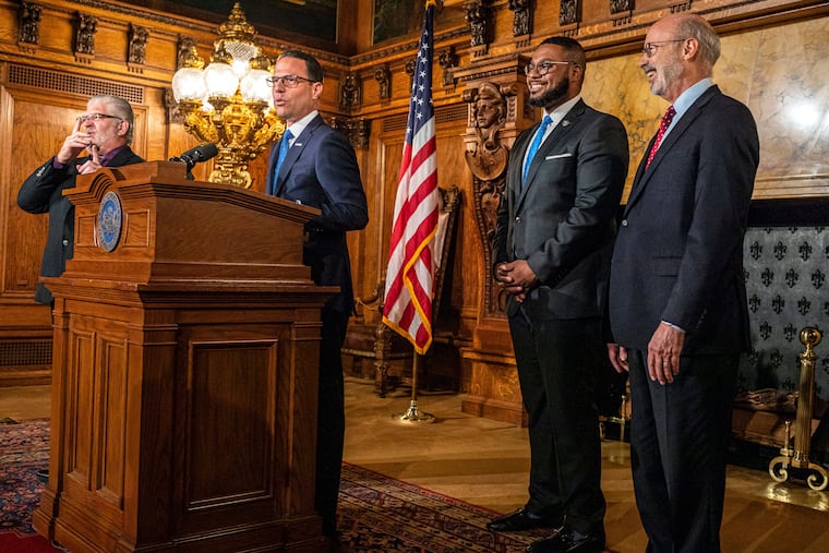 Pennsylvania Gov.-elect Josh Shapiro, at podium, and Lt. Gov.-elect Austin Davis, second right, join Gov. Tom Wolf, at right, during a news conference at the state Capitol in Harrisburg, Pa. last week.