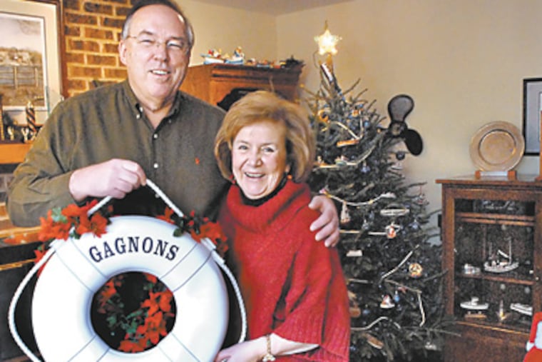 Ellen and Brian Gagnon in their rec room which has nautical-themed decorations and a tree with boat ornaments. ( April Saul / Staff Photographer )
