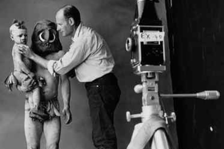 Photographer Irving Penn is shown working in his studio with two subjects, a New Guinea mud man and child. Penn died yesterday at his home in New York City. He was 92.