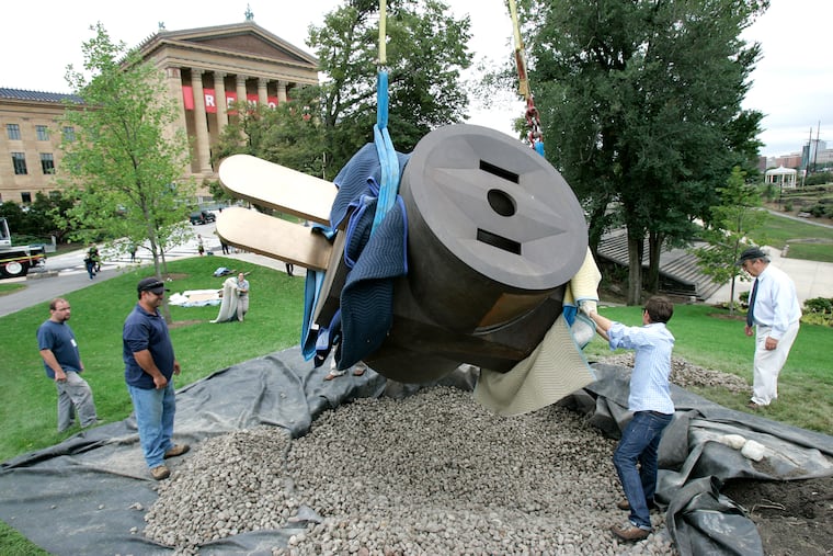 Artist Claes Oldenburg's Giant Three-way Plug donated by David Pincus is lifted into place on a grassy knoll behind the Philadelphia Museum of Art by workers from Atelier Art Services, in Aug 2010.