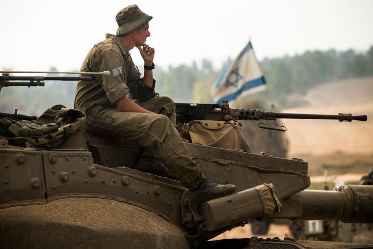 An Israeli soldier on a tank at the border. Premier Benjamin Netanyahu says the fighting won't end "until the mission is completed to protect our citizens, soldiers, and children."