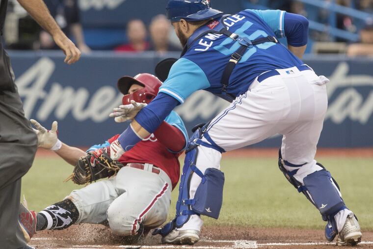 Phillies' infielder Scott Kingery gets mowed down at the plate on Friday.