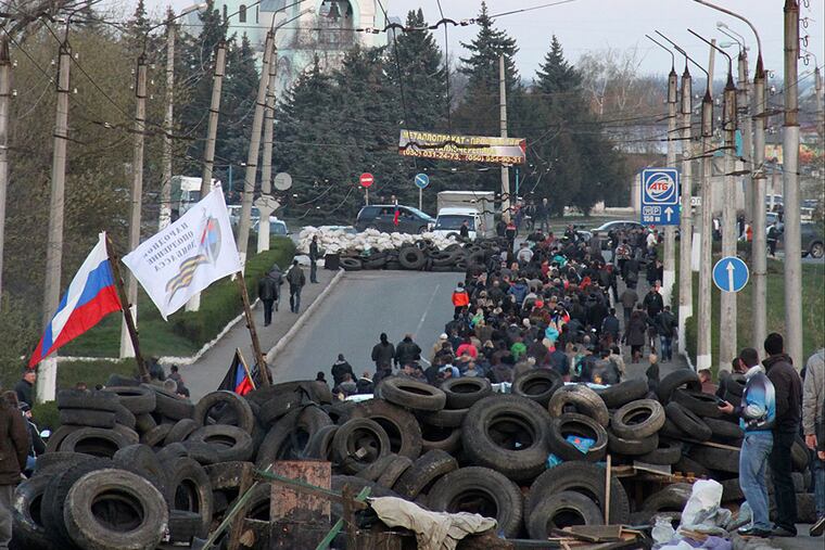 A pro-Russian crowd walks toward the airport in Kramatorsk, eastern Ukraine, where government forces clashed with a hostile group of protesters. ALEXANDER ERMOCHENKO / AP