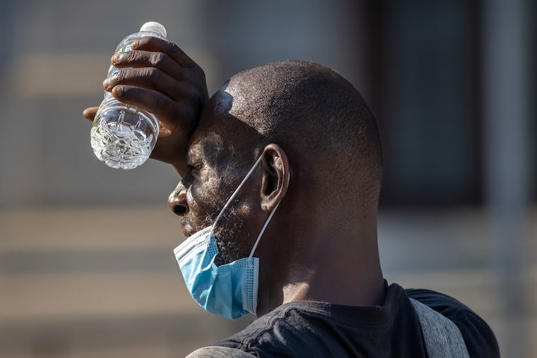 An unidentified man blocks the sun from his eyes as he looks west toward Filbert Street from the north side of Broad Street earlier this week.