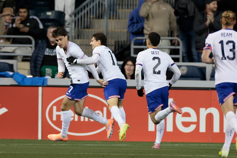 Gio Reyna (left) celebrates with teammate Brenden Aaronson and others after scoring the United States' first goal of the game in the first half vs. Paraguay on Saturday at Subaru Park in Chester.