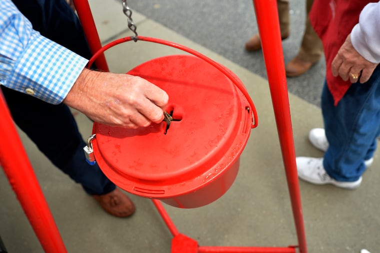 Money gets dropped into the kettle during the Annual Salvation Army Red Kettle drive in a 2018 file photo.