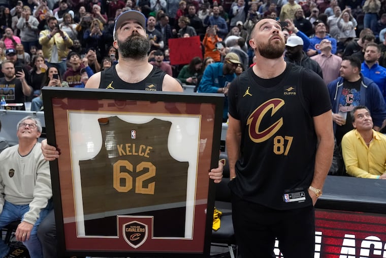 Jason Kelce, left, and Travis Kelce, right, watch a video tribute for Jason's retirement during a timeout at the Celtics-Cavaliers game on Tuesday.