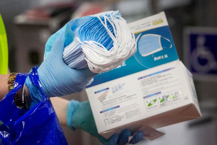 Jessica Mangold, project manager with SEPTA, hands out masks to riders at 69th Street Station in Upper Darby on Thursday.