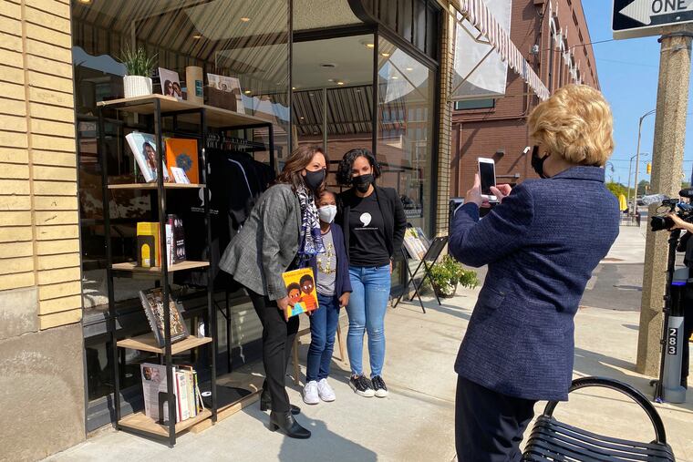 Michigan Sen. Debbie Stabenow, right, takes a picture of Vice President-elect Kamala Harris as she poses with Egypt Otis and her 9-year-old daughter Eva Allen on Sept. 22, 2020 in front of their Flint, Mich., bookstore, the Comma Bookstore & Social Hub. For countless women and girls, Harris' achievement of reaching the second-highest office in the country represents hope, validation and the shattering of a proverbial glass ceiling that has kept mostly white men perched at the top tiers of American government.