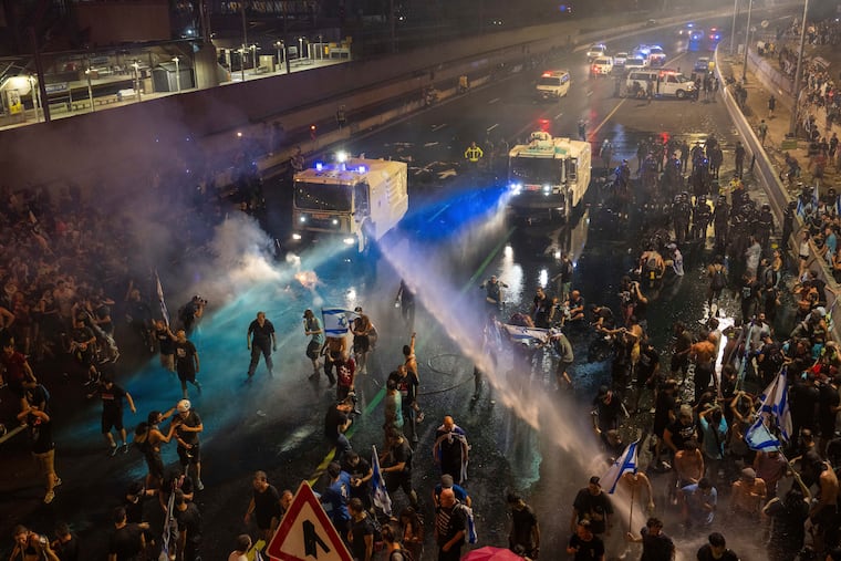 Riot police tries to clear demonstrators with a water canon during a protest against plans by Netanyahu's government to overhaul the judicial system, in Tel Aviv on Monday.