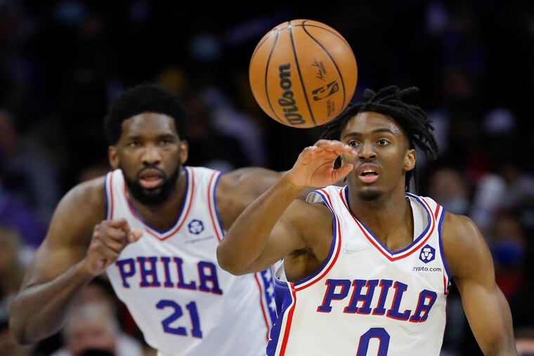 Sixers guard Tyrese Maxey going after the basketball with center Joel Embiid (21) against the Utah Jazz on Dec. 9.