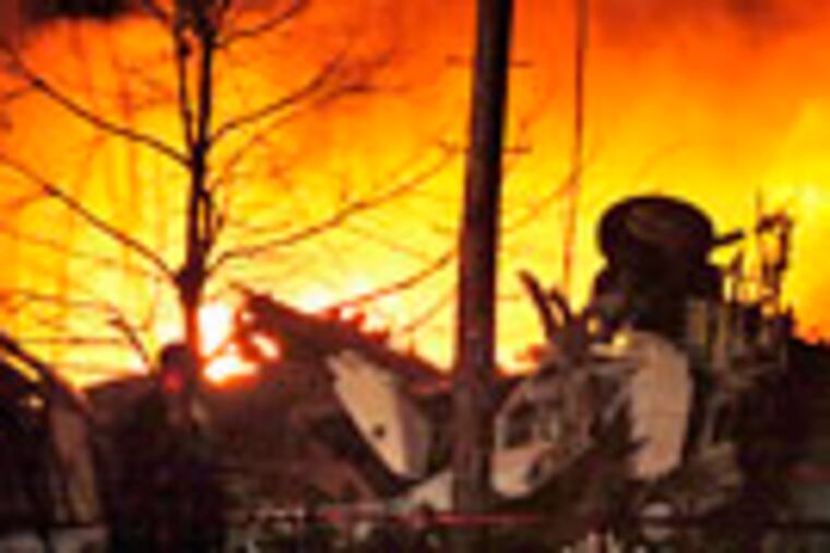 FILE - This Feb. 12, 2009 file photo, shows a plane burning after it crashed into a house in Clarence Center, N.Y. A cockpit voice recorder transcript released Tuesday May 12, 2009, by the National Transportation Safety Board, recounts the final moments of the flight crew as Flight 3407 plunged to the ground on approach to Buffalo Niagara International Airport.(AP Photo/David Duprey,file)