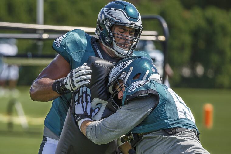 Eagle offensive lineman, #68 Jordan Mailata, left, holds the blocking pad and provides resistance to fellow lineman #62, Jason Kelce, right, during Sunday's practice at the NovaCare Center on September 2, 2018. MICHAEL BRYANT / Staff Photographer