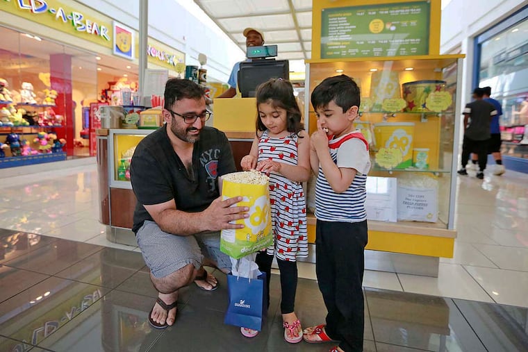 Laeeq Arshad with popcorn for his daughter Ayat and son Azan, at Cherry Hill Mall. Philadelphia is a walkable city, and popcorn is a good snack fit.