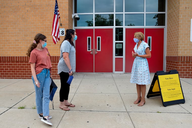 Amy Kennedy, then a Democratic candidate for New Jersey’s 2nd Congressional District, greets voters Karen Leonard and her daughter Katie, 14, on primary election day July 7, 2020, outside the Northfield Community School, where Kennedy worked as a teacher. Katie was picking up her eighth-grade graduation material.