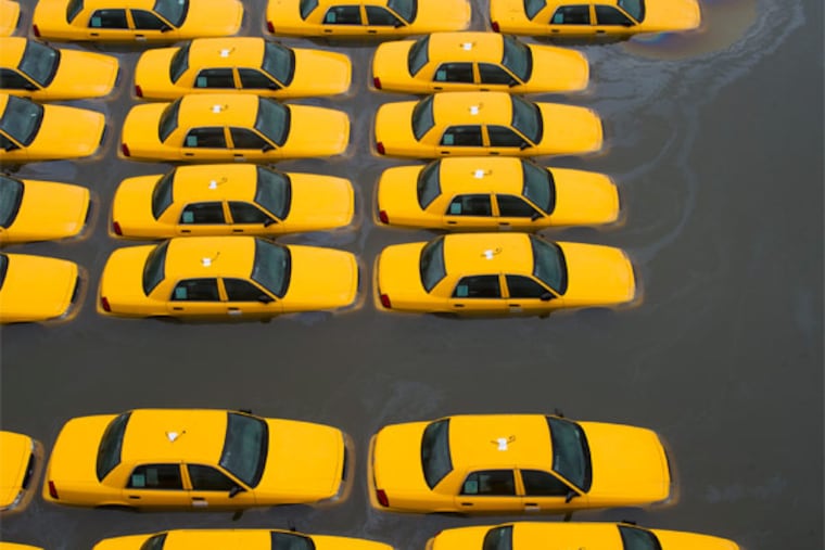 A parking lot full of yellow cabs is flooded as a result of superstorm Sandy on Tuesday, Oct. 30, 2012. (AP Photo/Charles Sykes)