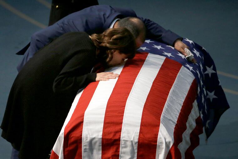 Lupe Corona and Merced Corona kiss the flag-draped coffin of their daughter, Davis Police Officer Natalie Corona, during funeral services at the University of California, Davis, Friday, Jan. 18, 2019, in Davis, Calif. Corona was was shot and killed Jan. 10, responding to scene of a three-car crash in Davis. Police say gunman Kevin Douglas Limbaugh, 48, not involved in the crash, rode up on a bicycle and, without warning, opened fire on Corona. (AP Photo/Rich Pedroncelli, Pool)