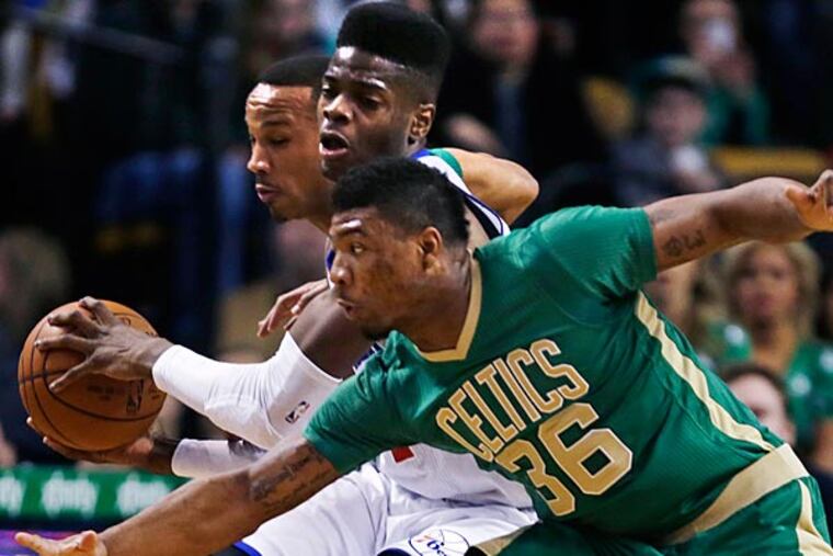 Philadelphia 76ers center Nerlens Noel is sandwiched between Boston
Celtics guards Marcus Smart (36) and Avery Bradley, rear, during the
first quarter of an NBA basketball game in Boston, Monday, March 16,
2015. (Charles Krupa/AP)