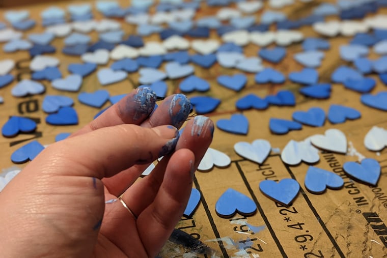 Casey Bien-Aime, spiritual care coordinator at Lankenau Medical Center, painted 296 wood hearts in shades of blue to represent Lankenau patients who died of COVID-19 between March 10, 2020 and March 10, 2021. She said it helped her cope with her own grief.