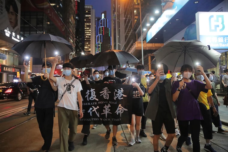 Pro-democracy demonstrators carry a banner reading "Librate Hong Kong, Revolution of our Time" during a protest marking the first anniversary of a mass rally against the now-withdrawn extradition bill in Hong Kong, Tuesday, June 9, 2020. One year ago, a sea of humanity, a million people by some estimates, marched through central Hong Kong on a steamy afternoon. It was the start of what would grow into the longest-lasting and most violent anti-government movement the city has seen since its return to China in 1997.