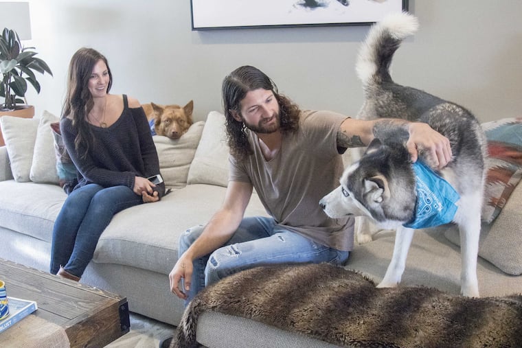 Linda Mencel (left) with her husband Patrick and their dogs Jagger (brown) and Alex (grey). The Mencels bought this house after saving three years for a down payment by taking turns living with both sets of parents.