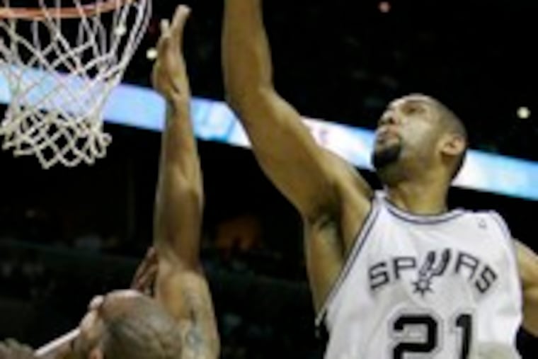 San Antonio's Tim Duncan (right) swats a shot by Utah's Carlos Boozer during the opening game of the Western Conference finals.The Spurs won, 108-100, yesterday. C3.