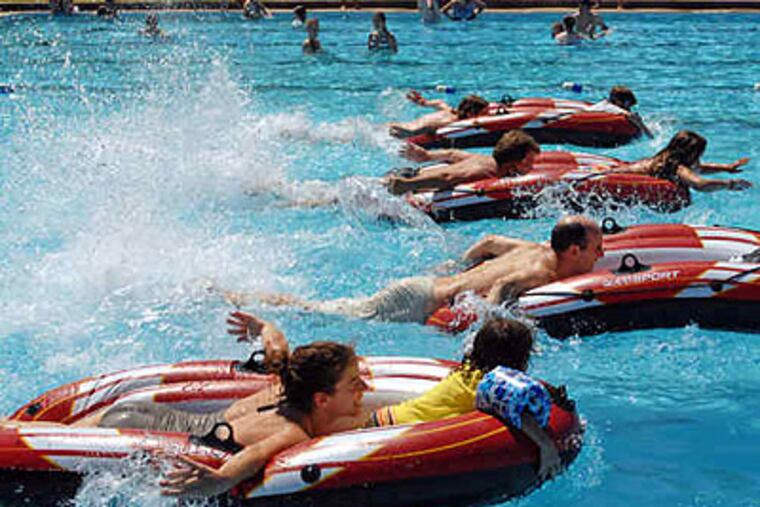 Parent-child teams race across Roberts Park Pool in Collingswood, part of the borough-owned pool's Fun on the Fourth celebration. (Tom Gralish / Staff)