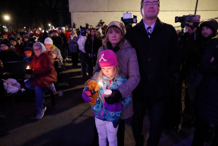 A small child takes part in a candle light vigil in downtown Waukesha, Wis., Nov. 22, after an SUV plowed into a Sunday Christmas parade killing multiple people and injuring dozens.
