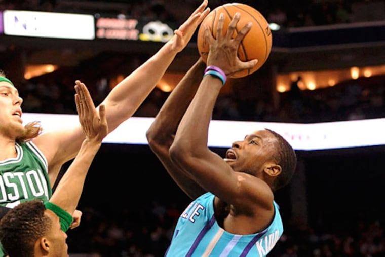 Charlotte Hornets forward Michael Kidd-Gilchrist (14) drives to the basket and shoots as he is defended by Boston Celtics center forward Kelly Olynyk (41) and guard forward Evan Turner (11) during the first half of the game at Time Warner Cable Arena. (Sam Sharpe/USA TODAY Sports)