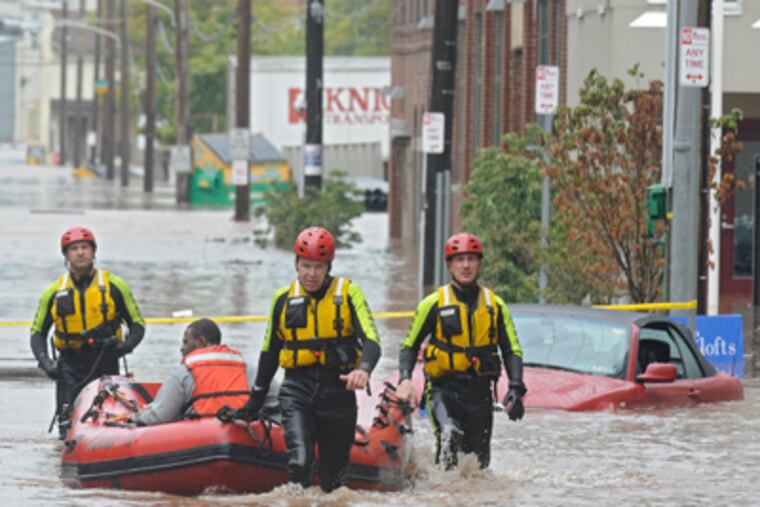Fire Department members rescue a resident at the flooded Venice Lofts apartments on Friday. (Clem Murray / Staff Photographer)