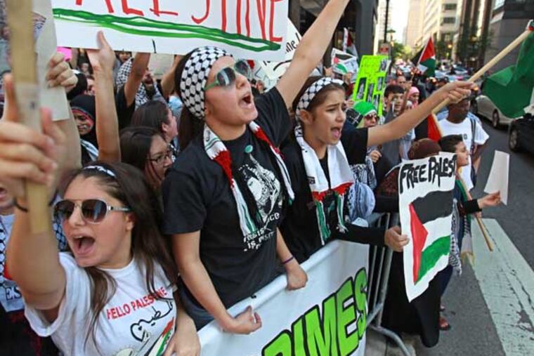 Jenan Ismail, 17, center, and Zainab masad. 12, right, raise their voices and flags and signs in protest to the Israeli incursion into Gaza at the intersection fo 19th and JFK Blvd friday afternoon. A large group of Palestinian protestors surrounded the intersection at 19th and JFK Blvd, near the Israeli consulate to raise their voices in protest to the Israeli incursion into Gaza. 07/25/2014 ( MICHAEL BRYANT / Staff Photographer )
