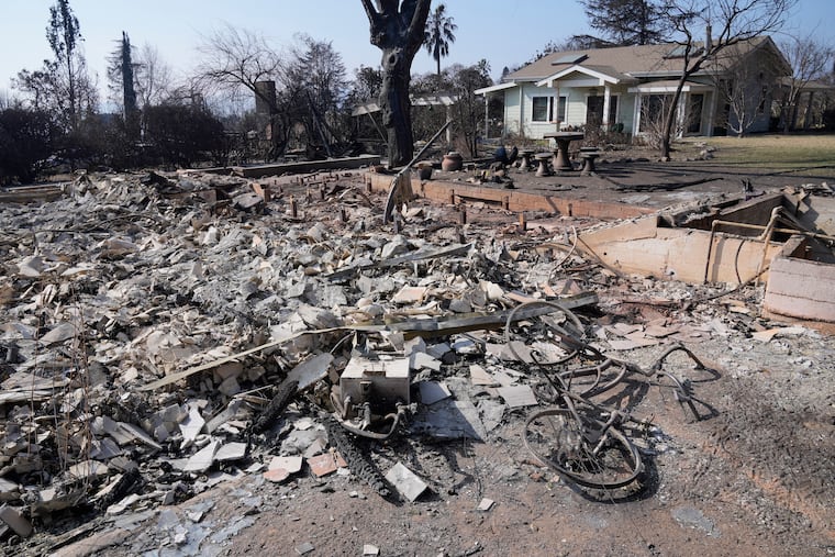 Debris from a destroyed home is seen as another house survived after the Eaton Fire, Sunday, Jan. 19, 2025, in Altadena, Calif.
