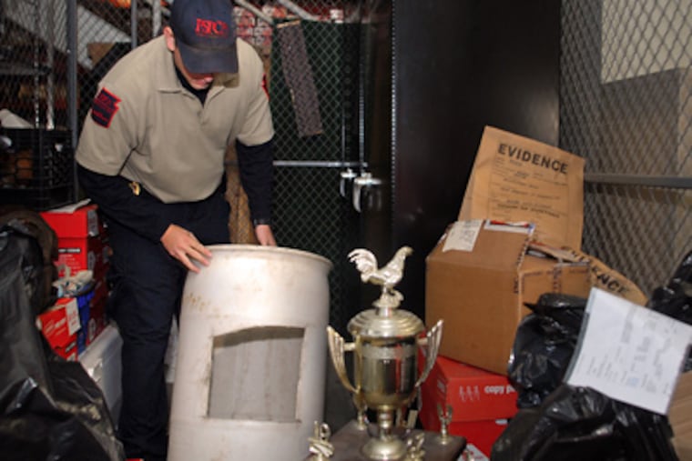 Humane Law Officer Derrick Schlitter displays evidence in a locker at the PSPCA. (Tom Gralish / Staff Photographer)