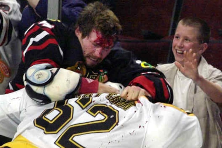 The Blackhawks' Bob Probert mixed it up with Boston's Andrei Nazarov (right) in 2001 as a young fan gleefully watched. Below, Probert took part in a Red Wings alumni game in 2007.