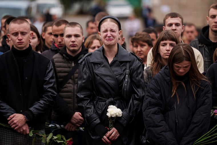 A woman cries during the funeral ceremony for a Ukrainian soldier. One study estimates Ukraine has seen 140,000 military deaths.