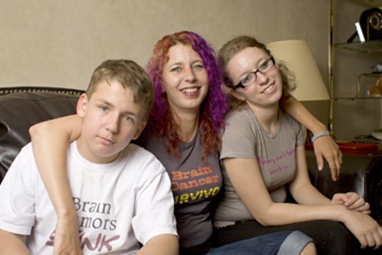 Niki Perry, 36, who has a brain tumor, with her children, Zach and Devin. She was so frustrated that doctors wouldn't tell her about other hospitals' trials that she now collects information for other patients. (Ed HIlle / Staff Photographer)