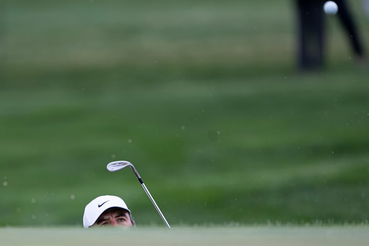 Scottie Scheffler hits a blind shot toward the 16th hole during practice ahead of the PGA Championship at Aronimink Golf Club.