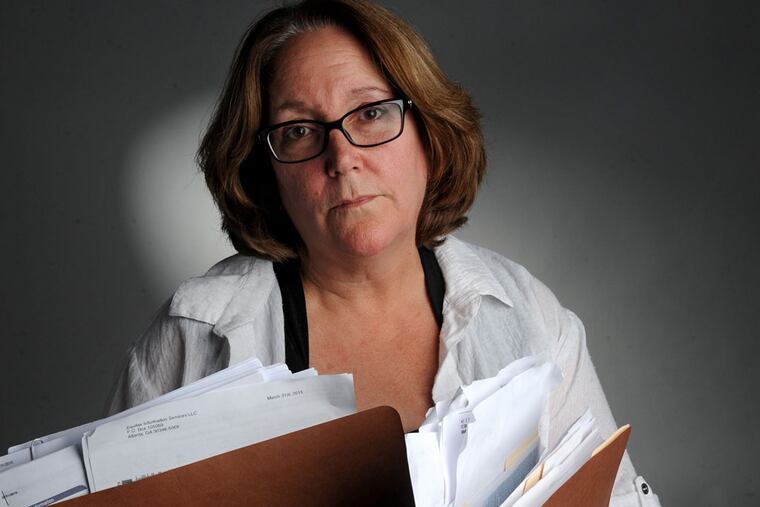 Christine Cortese holds packed folders full of correspondence from the IRS after her and her husband's identity were compromised, not once but twice, due to insufficient IRS security. (CLEM MURRAY
/ Staff Photographer)