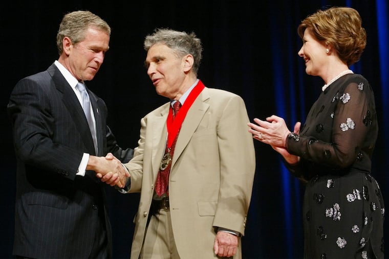 President George W. Bush, left, shakes hands with Robert Coles, a child psychologist, researcher and professor of psychiatry, as first lady Laura Bush looks on during the National Endowment for the Arts Awards ceremony at Constitution Hall, April 22, 2002, in Washington.