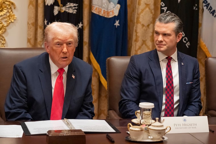 President Donald Trump, with Defense Secretary Pete Hegseth at his side, leads a cabinet meeting Tuesday at the White House.